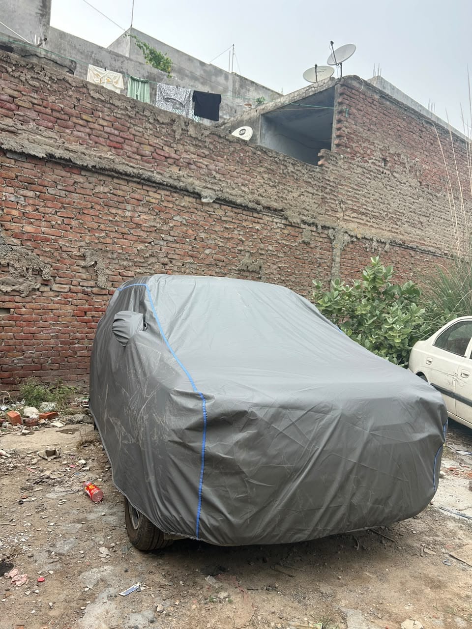 Grey car cover on a parked hatchback